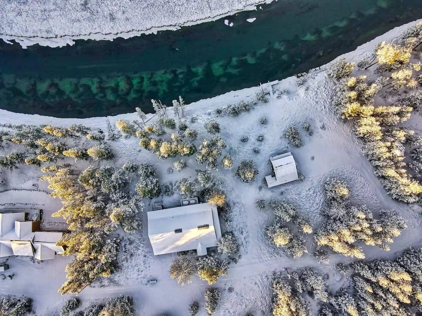 A snow-covered landscape with houses and trees, alongside a river, Deschutes Riverfront Retreat near Sunriver, Oregon